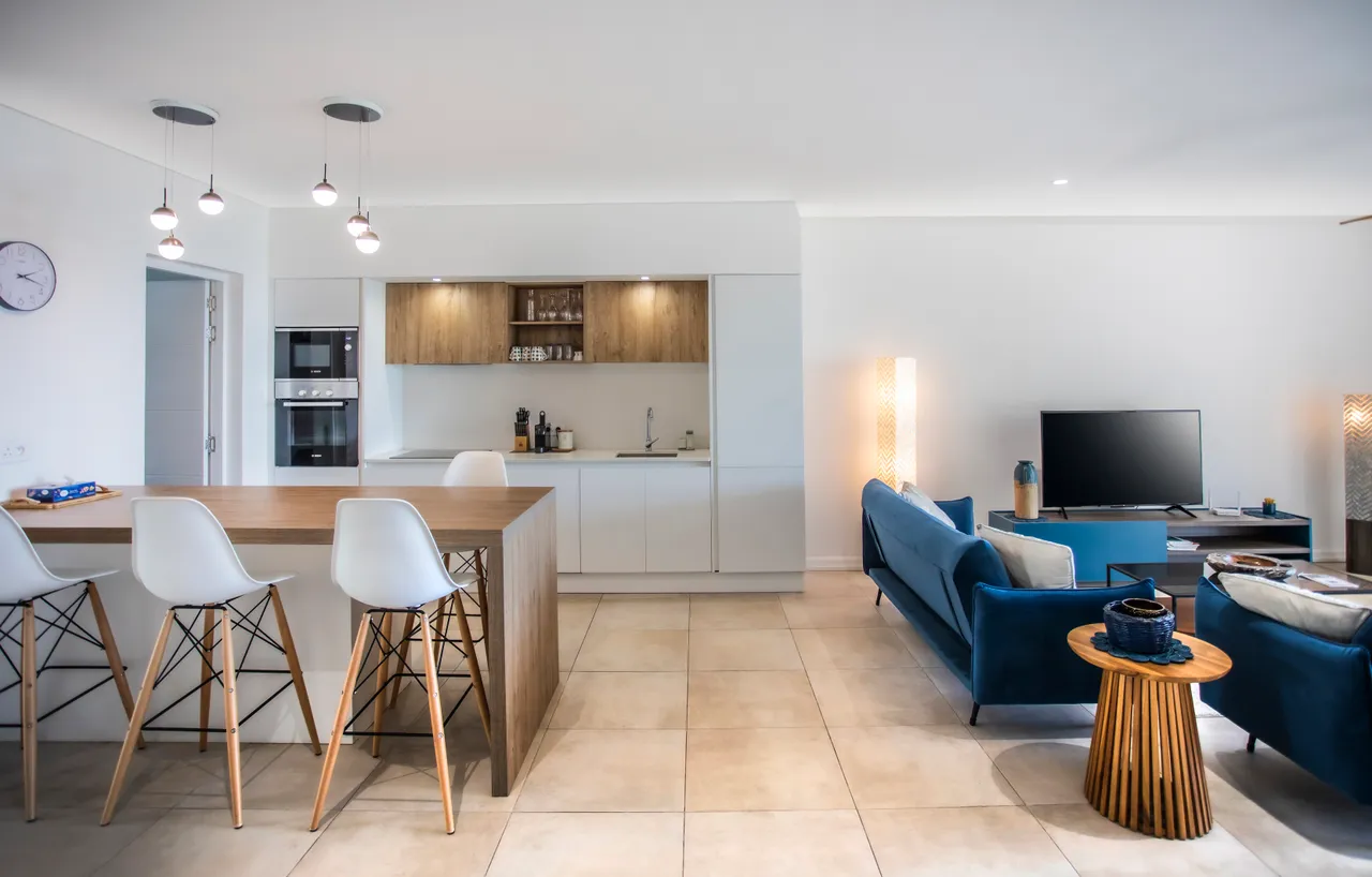 Espace de vie contemporain avec coin repas et électroménagers intégrés. Mobilier fonctionnel.