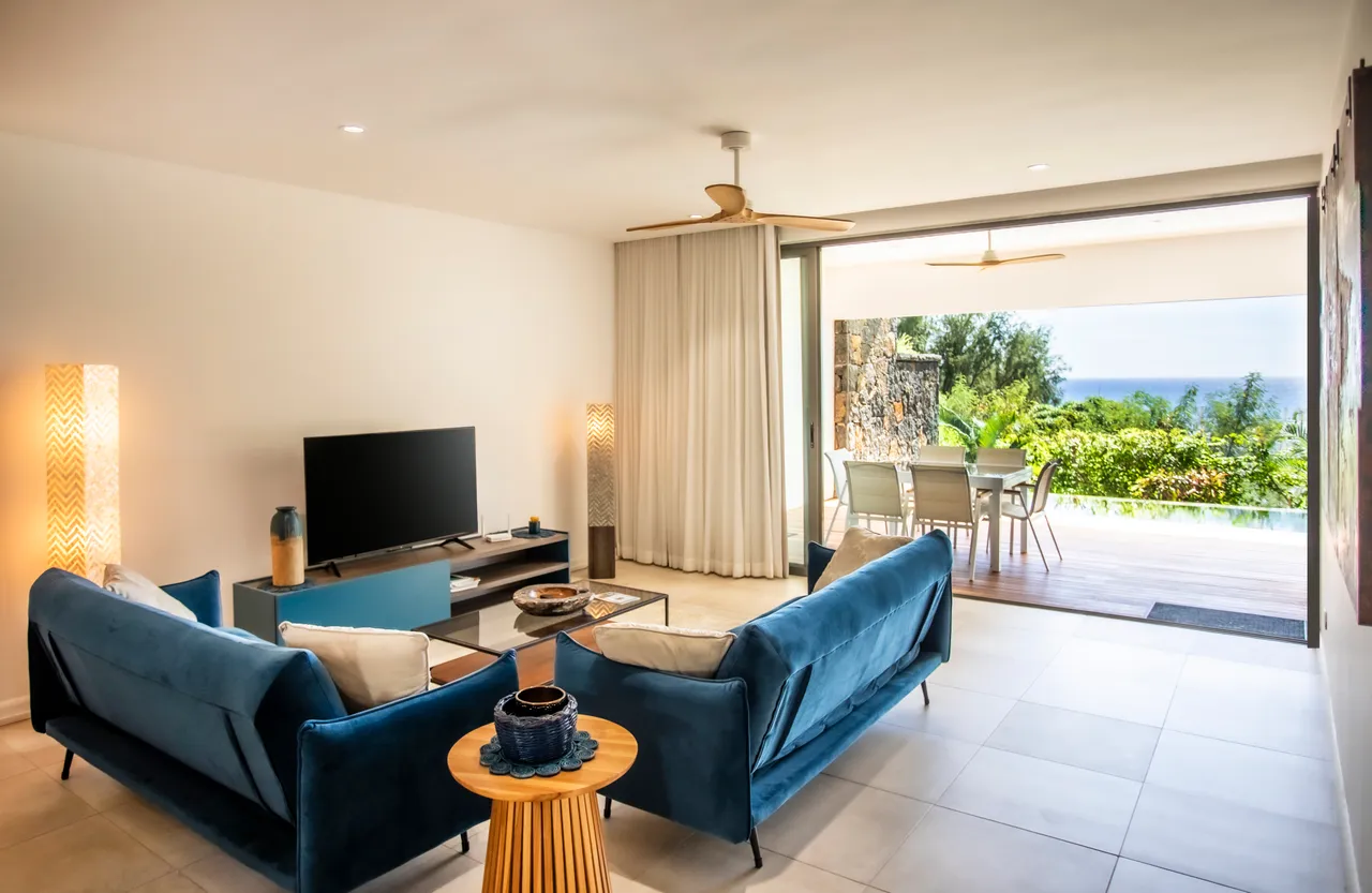 Séjour spacieux avec grandes baies vitrées, offrant accès direct à la terrasse. Vue sur la mer.