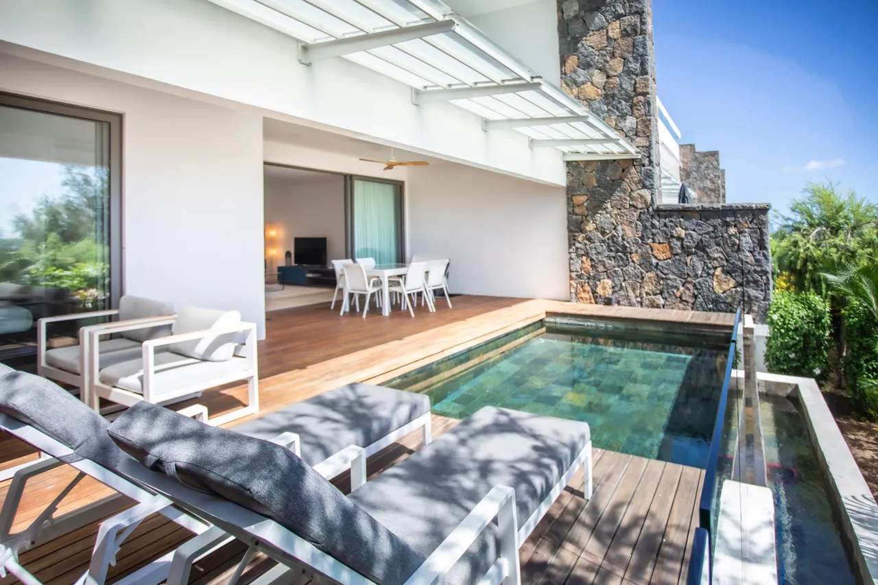 Tons neutres et mobilier contemporain sur la terrasse. Accès direct à la piscine et vue sur la mer.
