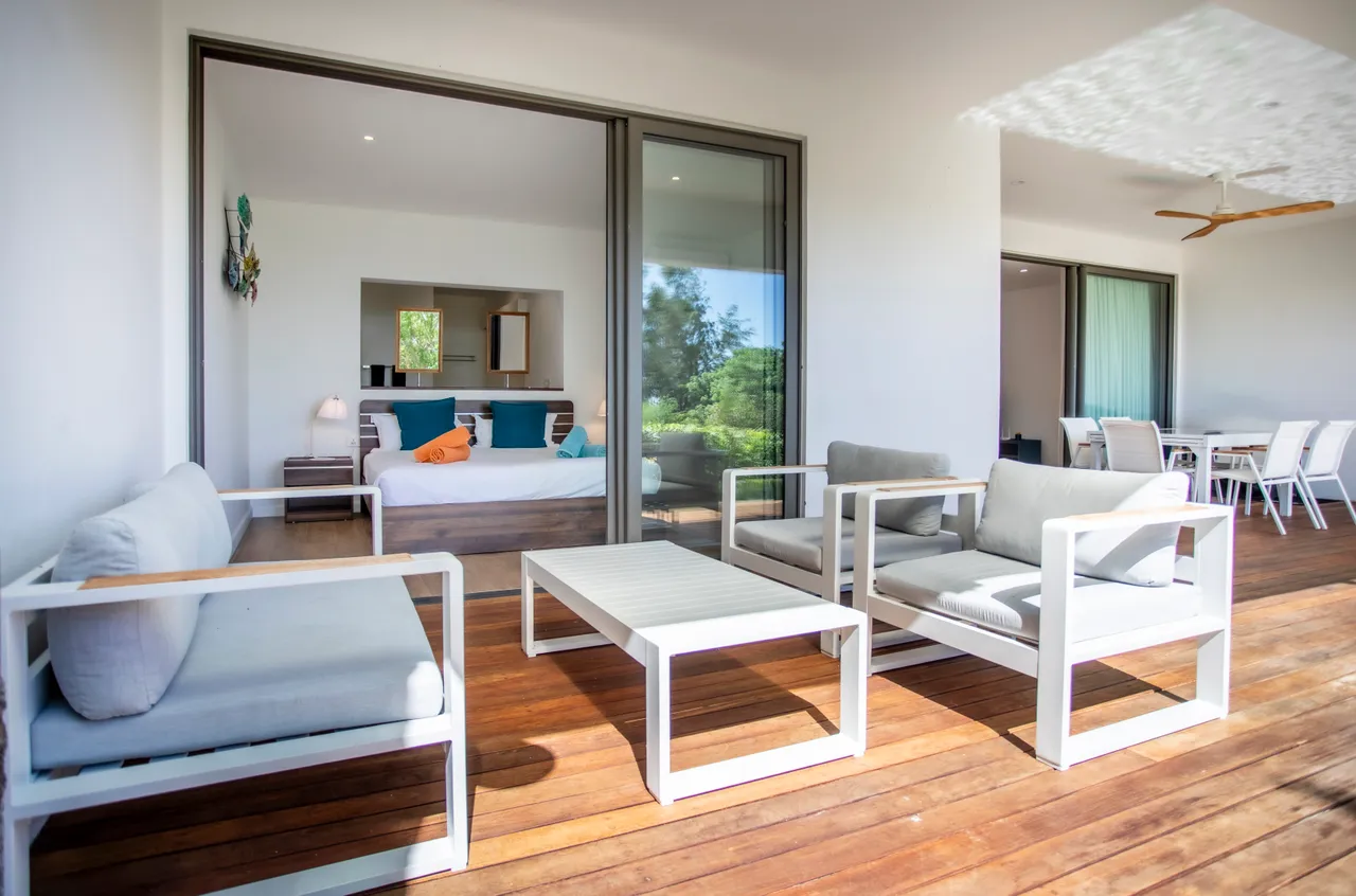 Espace extérieur avec mobilier en teck, offrant une vue sur le jardin. Coin détente lumineux et accueillant.