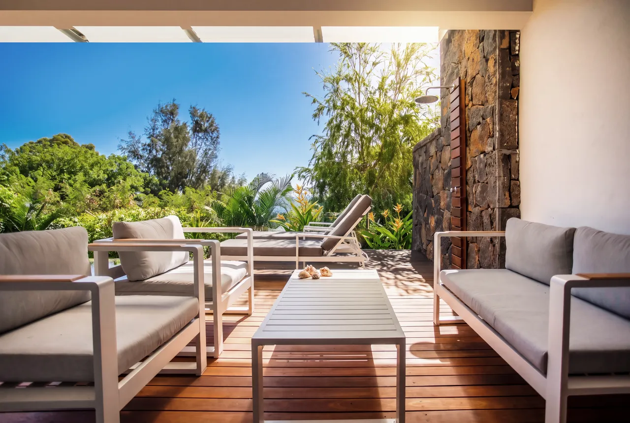 Coin salon extérieur avec mobilier moderne, vue dégagée sur la verdure.
