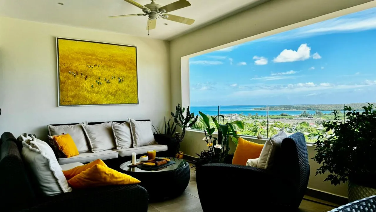 Tons neutres et mobilier en rotin, le salon bénéficie d'une vue sur la mer.