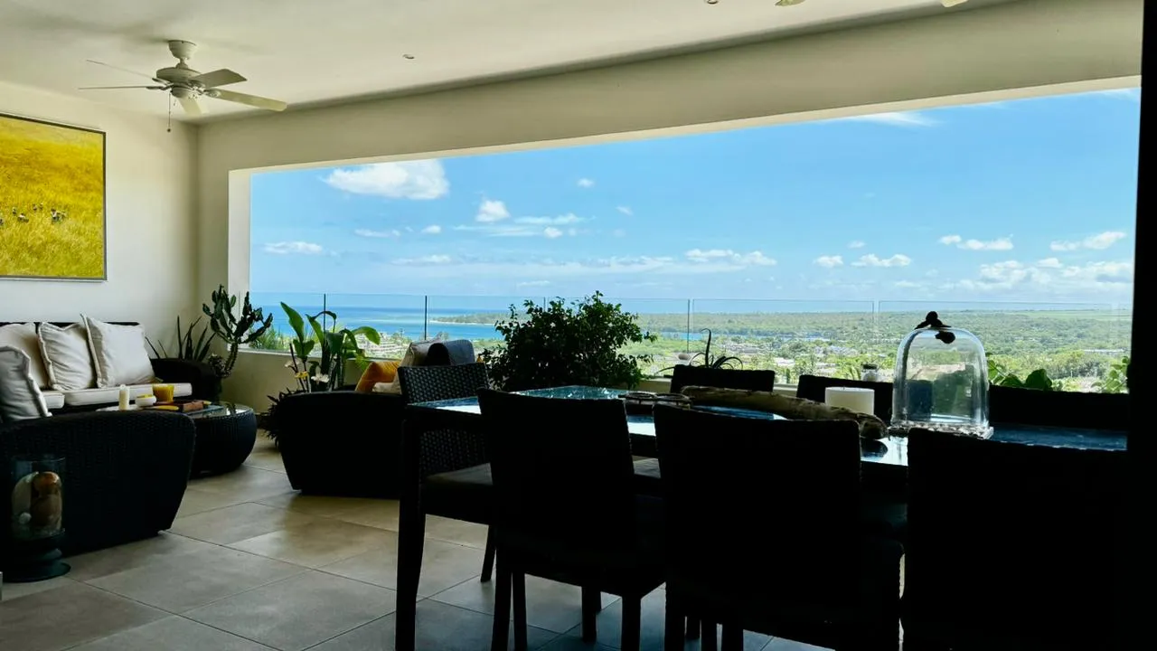 Teintes claires et mobilier en rotin. Espace de vie avec vue panoramique sur la mer.