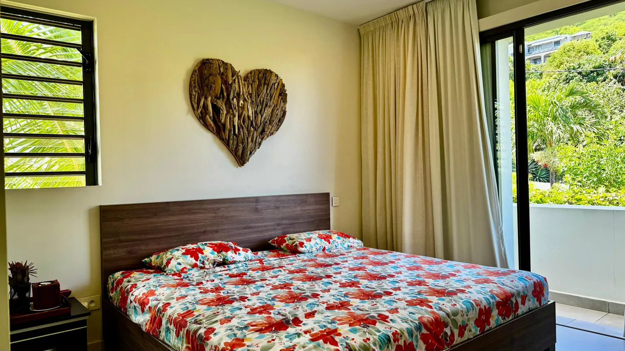 Tons chauds sur les murs d'une chambre avec un lit double. Décoration en bois ajoutant une touche naturelle.