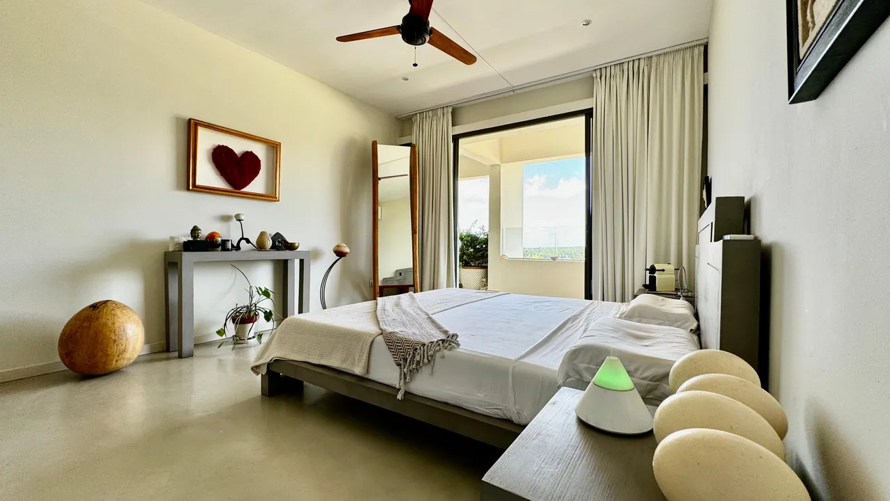 Chambre avec lit double et accès à un balcon privé. Décoration minimaliste et naturelle.