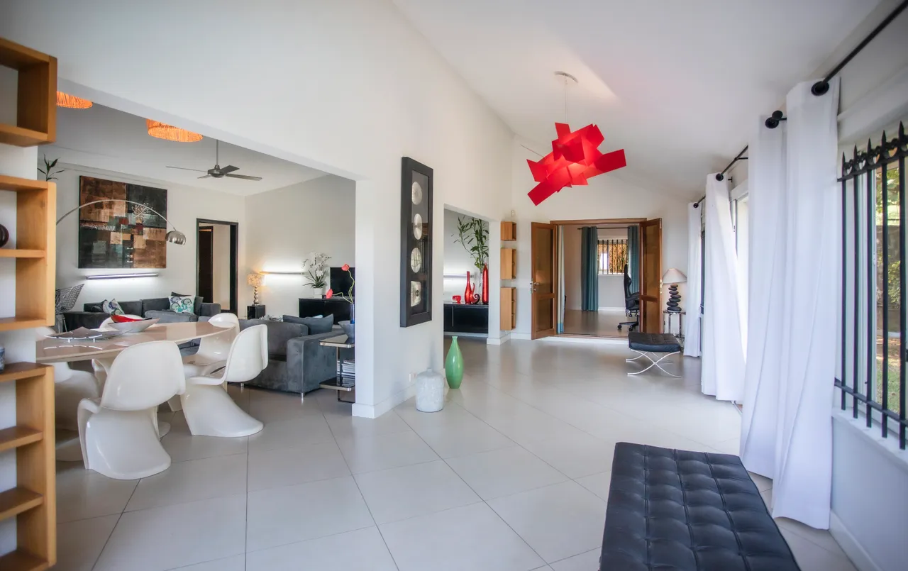 Couleurs claires dominent l'espace de la galerie.  
Mobilier moderne et lumineux se combine avec des éléments décoratifs.  
Le sol carrelé offre une ambiance fraîche et contemporaine.  
L'architecture permet une circulation fluide entre les différentes zones.  
Espace baigné de lumière naturelle grâce aux grandes fenêtres.