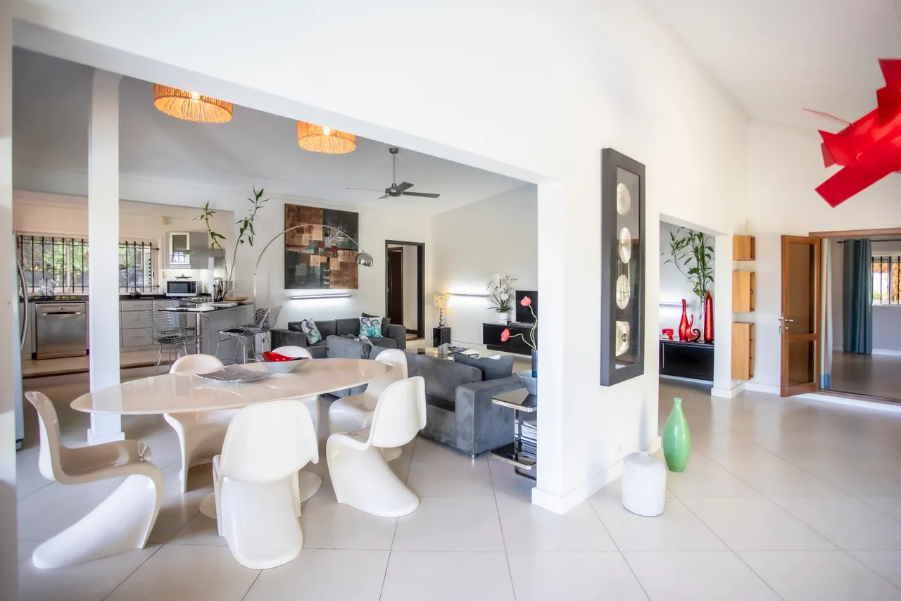 Espace de la galerie avec un coin repas et un agencement ouvert.  
Le mobilier moderne s'harmonise avec des éléments décoratifs.  
Lumineux grâce aux grandes fenêtres qui apportent une lumière naturelle.  
Les couleurs neutres créent une atmosphère contemporaine et apaisante.  
Coin salon spacieux avec fauteuils confortables et tables basses.
