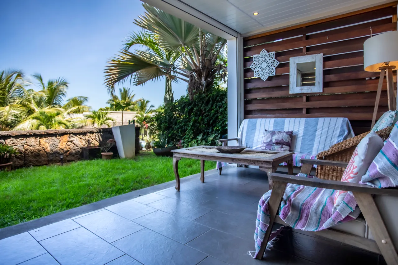 Espace cosy avec vue sur jardin tropical et piscine.