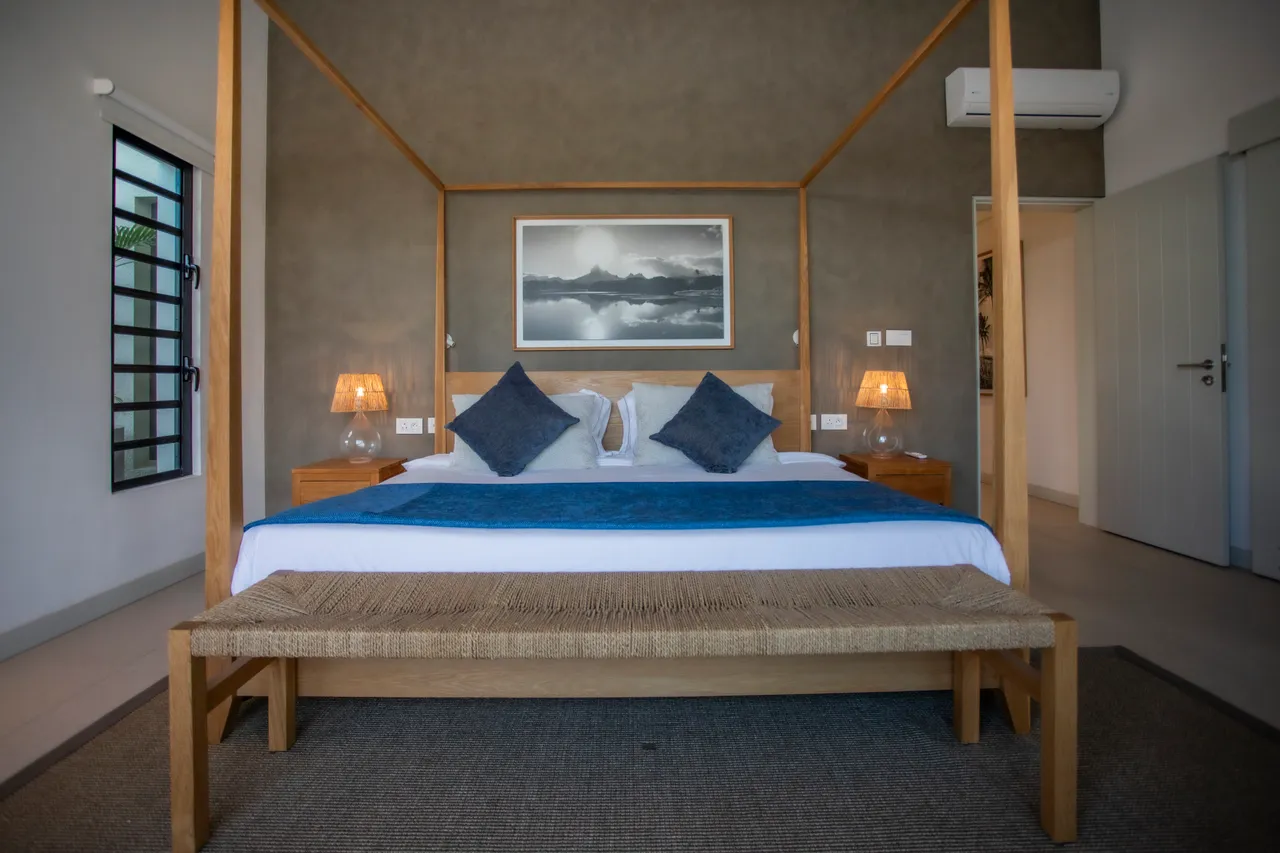 Chambre 1 avec lit à baldaquin et éclairage doux. 

Mobilier en bois ajoutant une touche naturelle à la pièce. 

Tons neutres des murs créant une ambiance apaisante. 

Fenêtres laissant entrer la lumière naturelle tout au long de la journée. 

Espace de rangement intégré optimisant l'utilisation de la pièce.