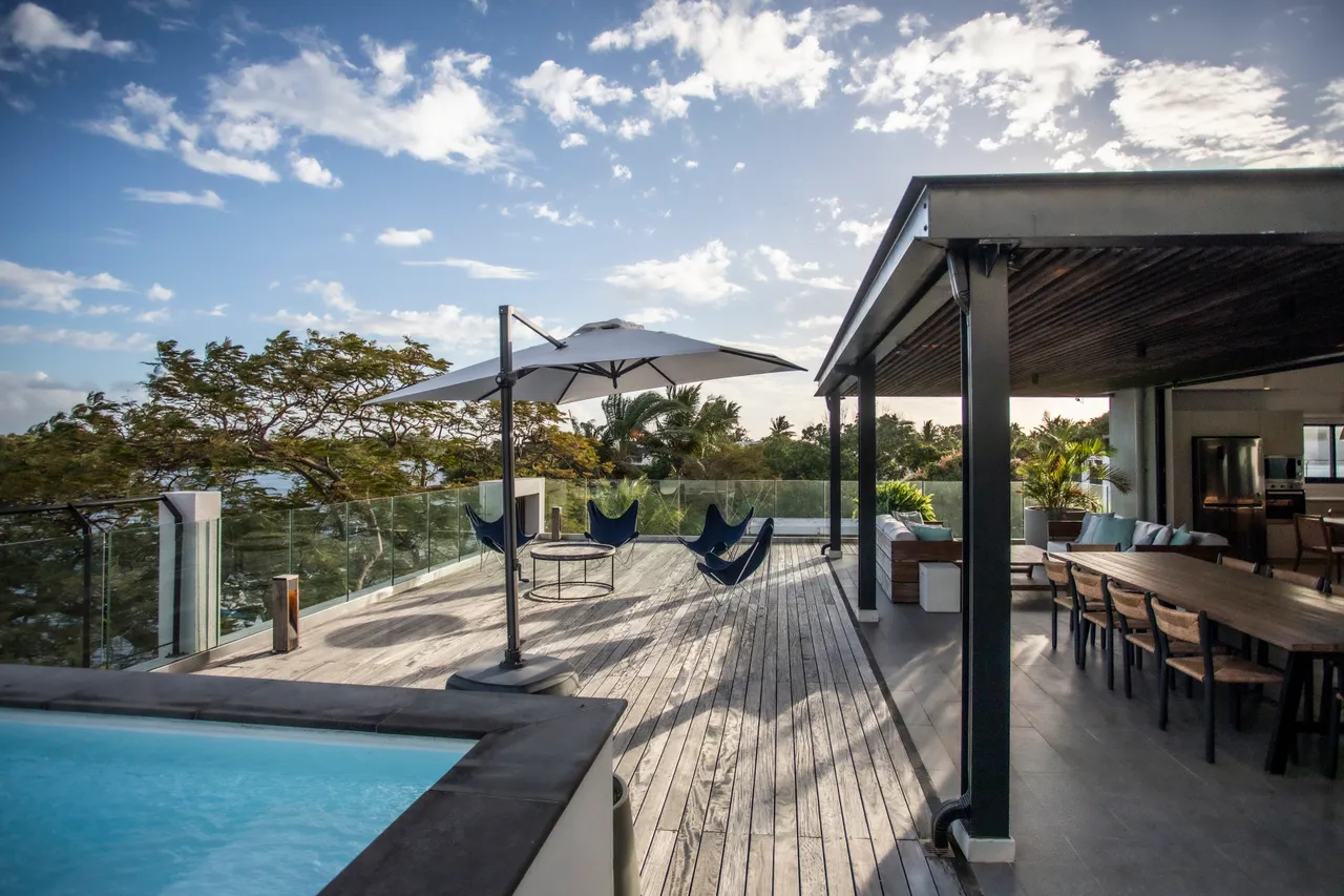 Terrasse spacieuse avec piscine privée et vue dégagée sur la nature. 

Mobilier d'extérieur en bois ajoutant du confort à l'espace. 

Parasols offrant de l'ombre pour des moments de détente. 

Zone repas extérieure avec grande table pour des repas conviviaux. 

Chaises longues positionnées près de la piscine pour se relaxer.