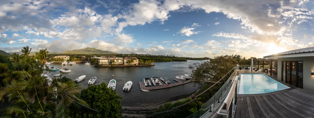 Vue panoramique sur le port depuis la terrasse spacieuse. 

Terrasse en bois équipée d'une piscine pour se rafraîchir. 

Mobilier extérieur moderne favorisant la détente au bord de l'eau. 

Végétation dense entourant l'espace pour plus d'intimité. 

Coucher de soleil illuminant le paysage maritime.