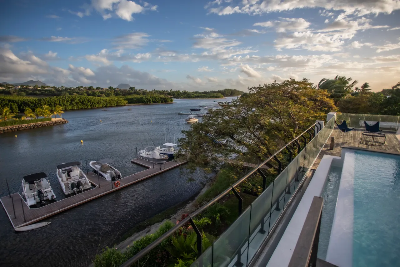 Terrasse en bois avec piscine privée offrant une vue sur le port. 

Chaises longues modernes disposées pour se détendre au soleil. 

Végétation luxuriante encadrant l’espace extérieur pour plus d’intimité. 

Eau calme du port créant une ambiance sereine et apaisante. 

Espace de vie lumineux avec accès direct à la terrasse.