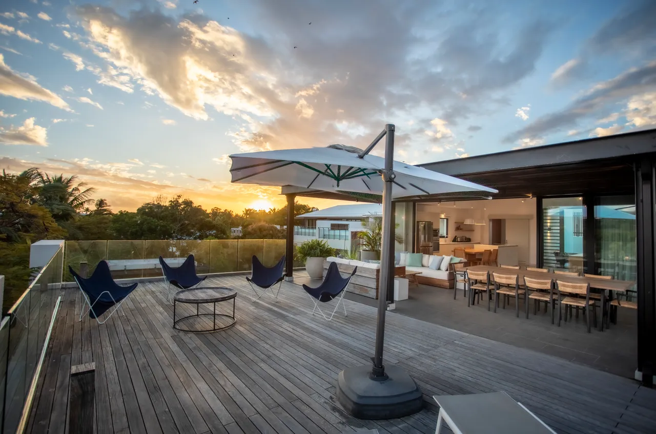 Terrasse spacieuse avec mobilier moderne et parasol pour se protéger du soleil. 

Vue panoramique sur le paysage environnant, ajoutant une dimension naturelle. 

Espace extérieur bien agencé pour des moments conviviaux en plein air. 

Chaises longues disponibles pour se détendre tout en profitant du coucher de soleil. 

Accès direct à l'intérieur depuis la terrasse, facilit