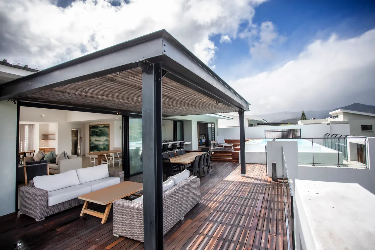 Terrasse spacieuse avec mobilier en bois pour des moments conviviaux en extérieur.  
Piscine privée à proximité, offrant une vue dégagée sur l'environnement.  
Zone ombragée permettant de profiter de l'extérieur tout en restant au frais.  
Agencement fonctionnel favorisant le confort pour les loisirs en plein air.  
Espace extérieur bien aménagé pour des repas en plein air