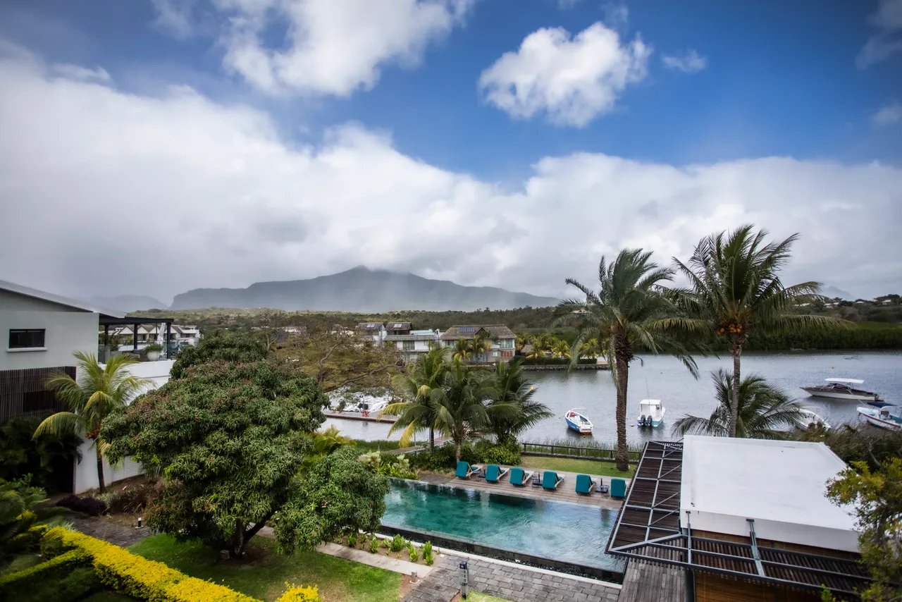 Penthouse avec piscine privée offrant une vue sur la nature environnante.  
Terrasse spacieuse avec chaises longues pour se détendre au soleil.  
Espace extérieur bien aménagé, idéal pour profiter de l'environnement.  
Végétation luxuriante entourant la piscine apportant une ambiance naturelle.  
Coin repas extérieur pour des repas en plein air au bord de l'eau.
