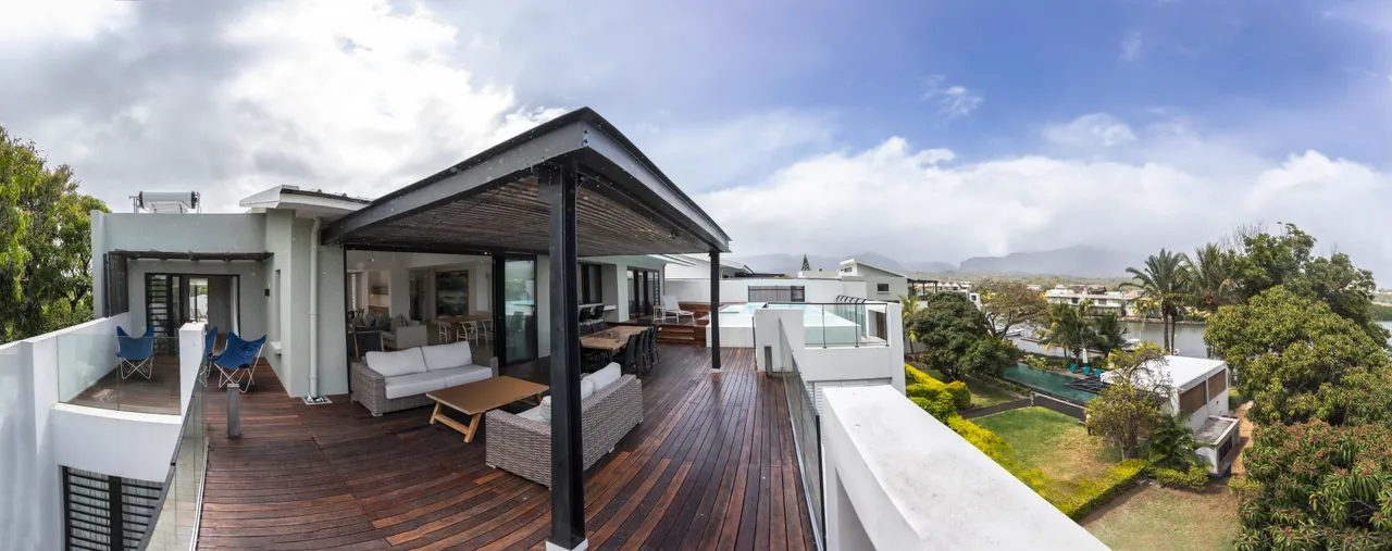Terrasse en bois spacieuse avec vue sur la végétation environnante.  
Canapé en rotin offrant un espace confortable pour se détendre.  
Espace extérieur équipé d'une piscine privée pour des moments de rafraîchissement.  
Coin repas en plein air permettant de profiter des repas sous le ciel.  
Végétation abondante créant une ambiance naturelle autour de l'espace extérieur