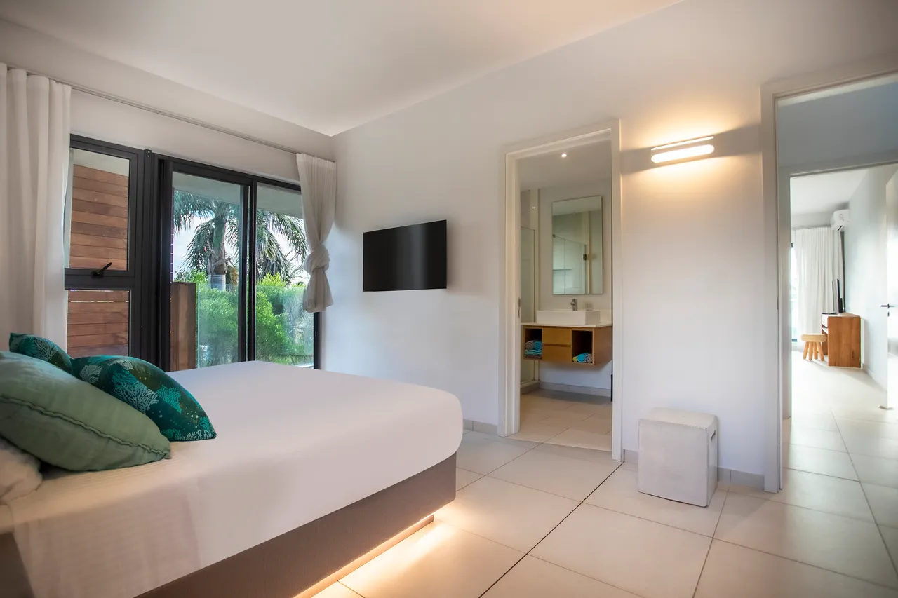 Chambre avec un lit double et télévision murale. Accès direct à l'extérieur.