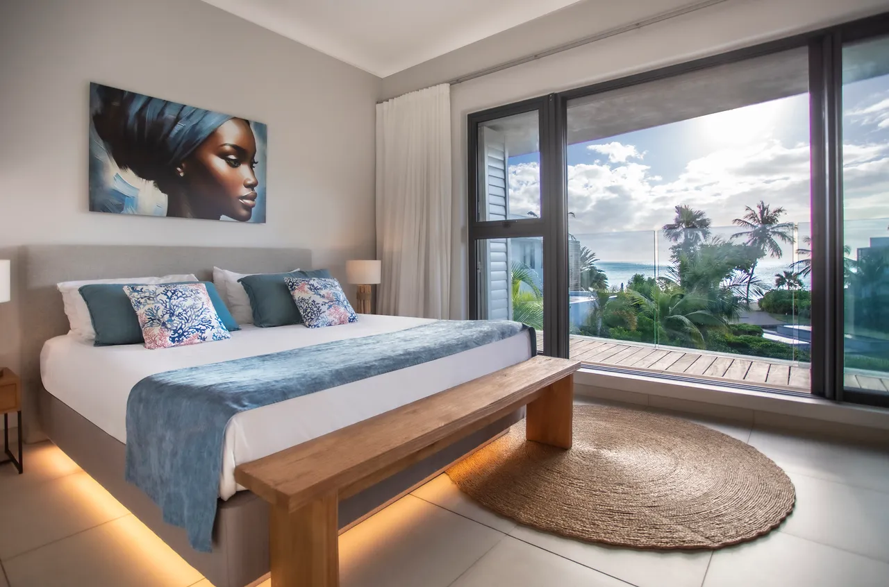 Chambre avec lit queen-size et vue sur la mer. Grand balcon en bois pour profiter de l'extérieur.