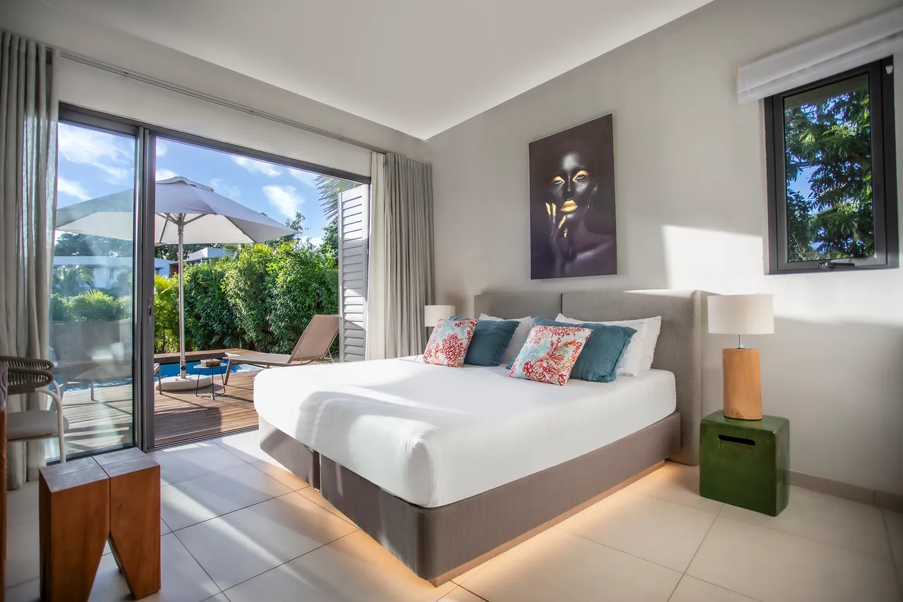 Tons neutres dans la chambre, avec accès direct à la terrasse. Lit double et éclairage agréable.