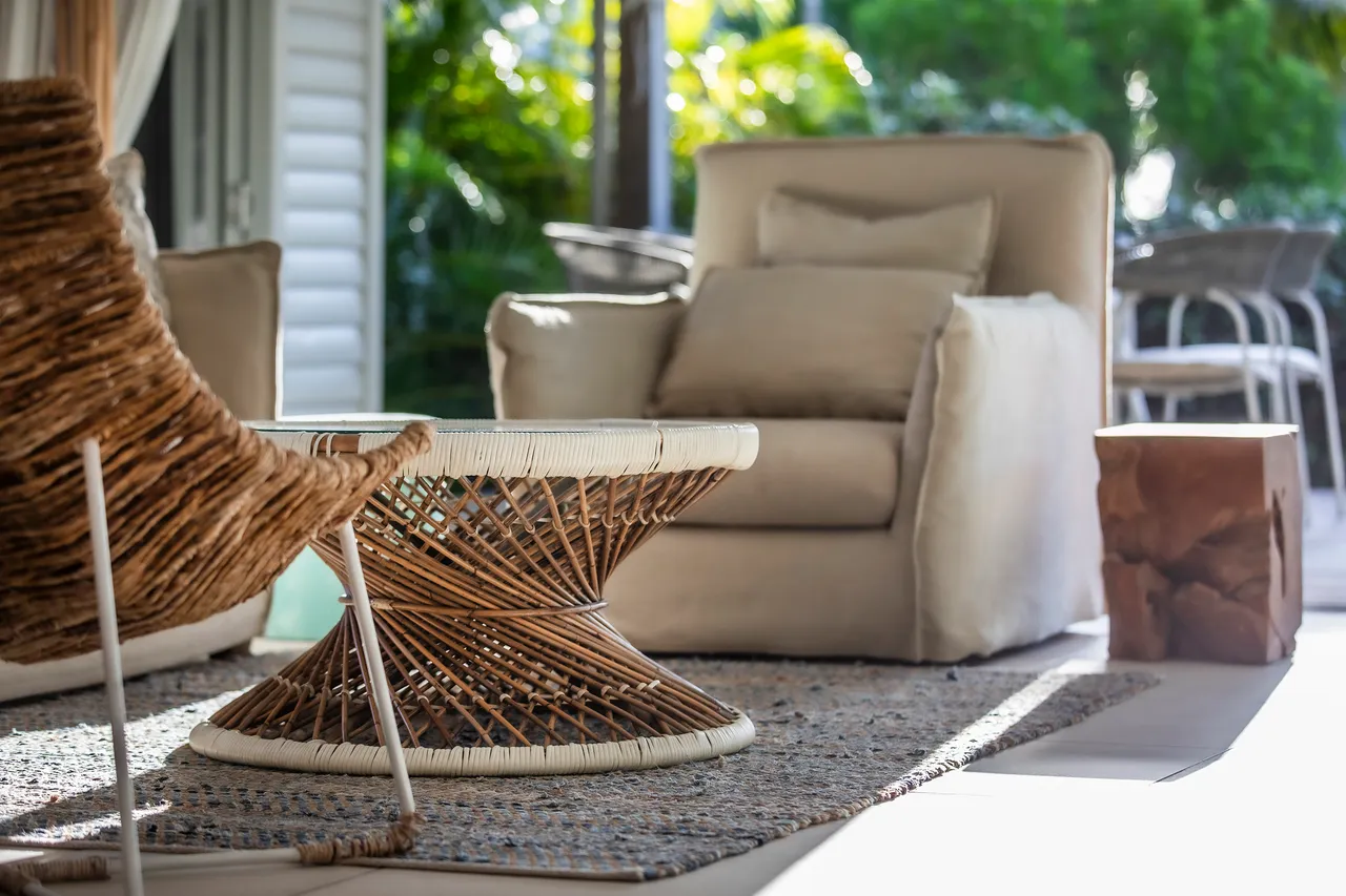 Espace extérieur avec mobilier en rotin et vues sur la nature environnante.