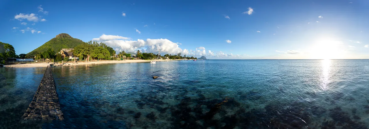 Vue panoramique sur l'océan depuis la plage à proximité. Coucher de soleil illuminant l'horizon.