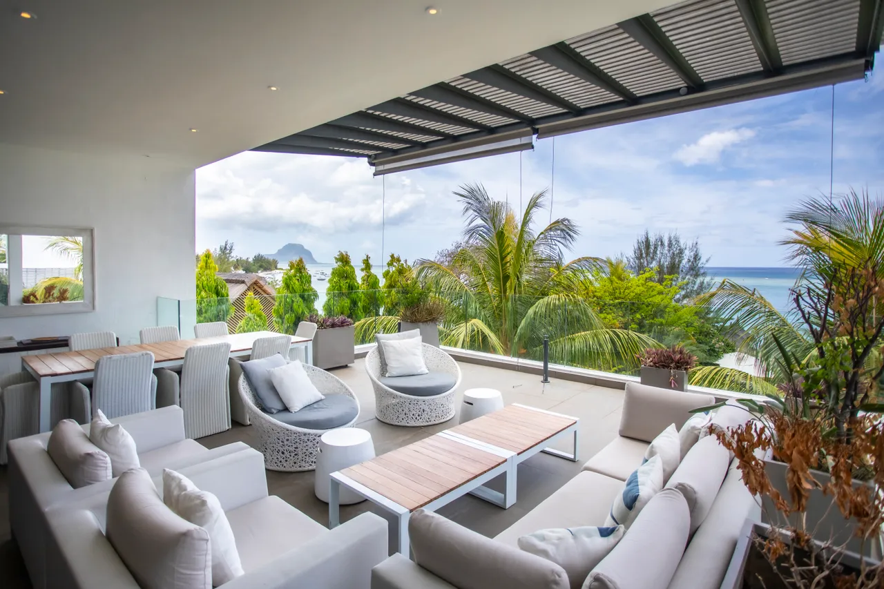 Terrasse équipée de canapés confortables offrant une vue dégagée sur la mer.
