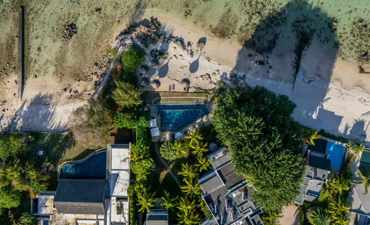 Tons de vert et de bleu, vue sur la plage depuis le penthouse. Piscine entourée de jardins tropicaux.