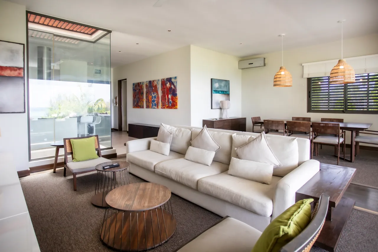 Tons neutres et texture douce caractérisent ce salon spacieux. Accès direct à la terrasse avec vue sur l'extérieur.