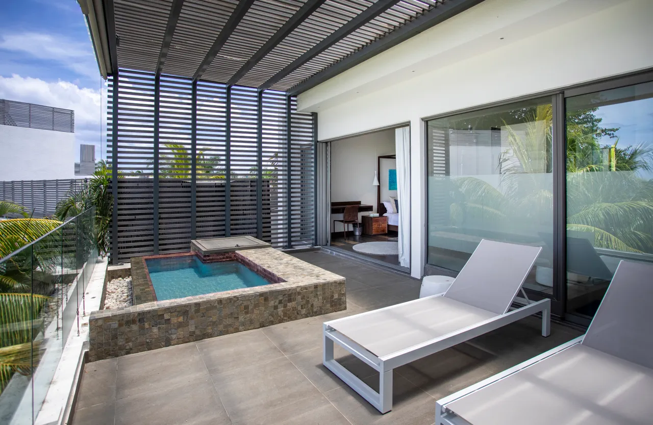 Terrasse spacieuse avec piscine privée et chaises longues. Cadre verdoyant tout autour.