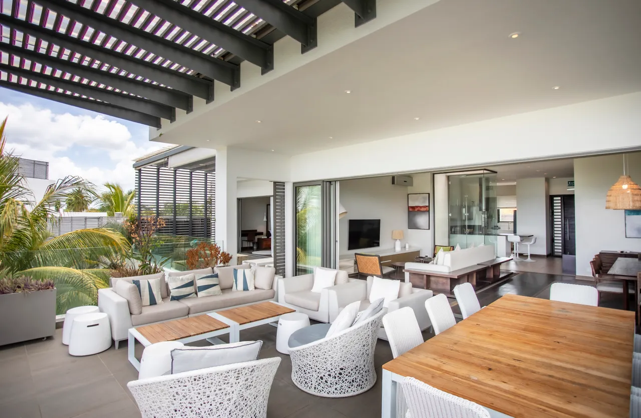 Teintes blanches et bois clair dominent cet espace repas ouvert sur la terrasse. Mobilier contemporain favorise une ambiance conviviale et lumineuse.