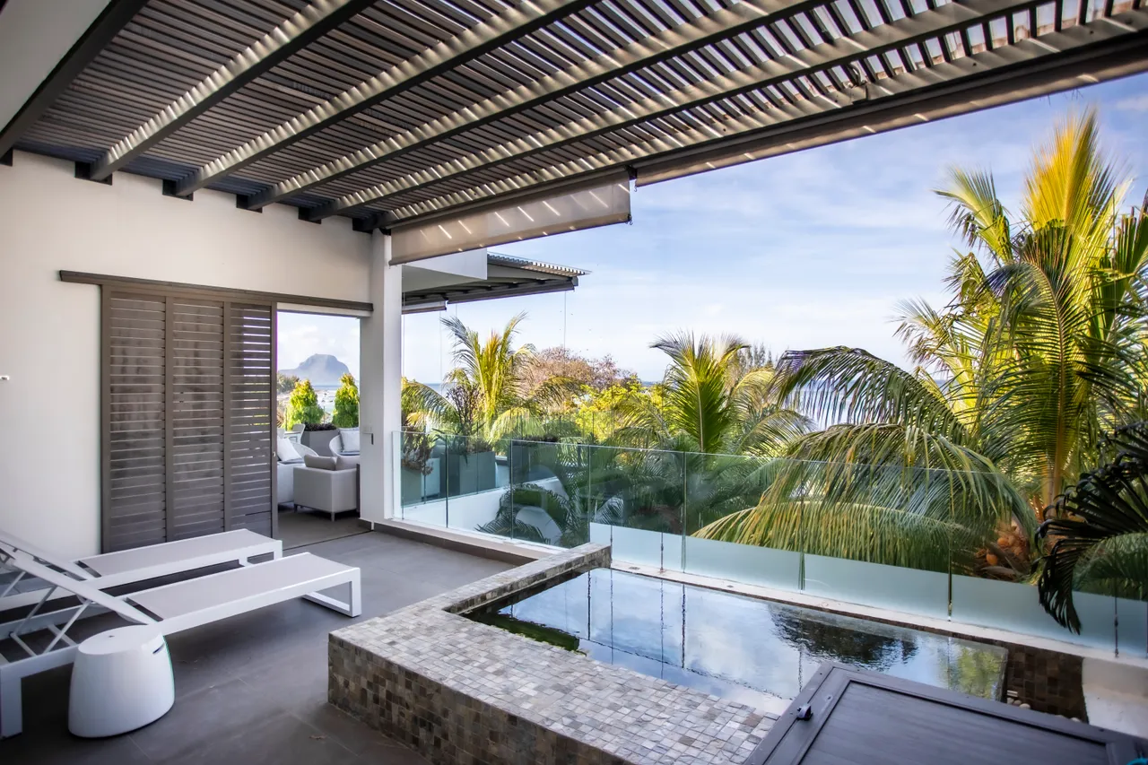 Teintes neutres et mobilier moderne sur la terrasse. Petite piscine avec vue sur la végétation.