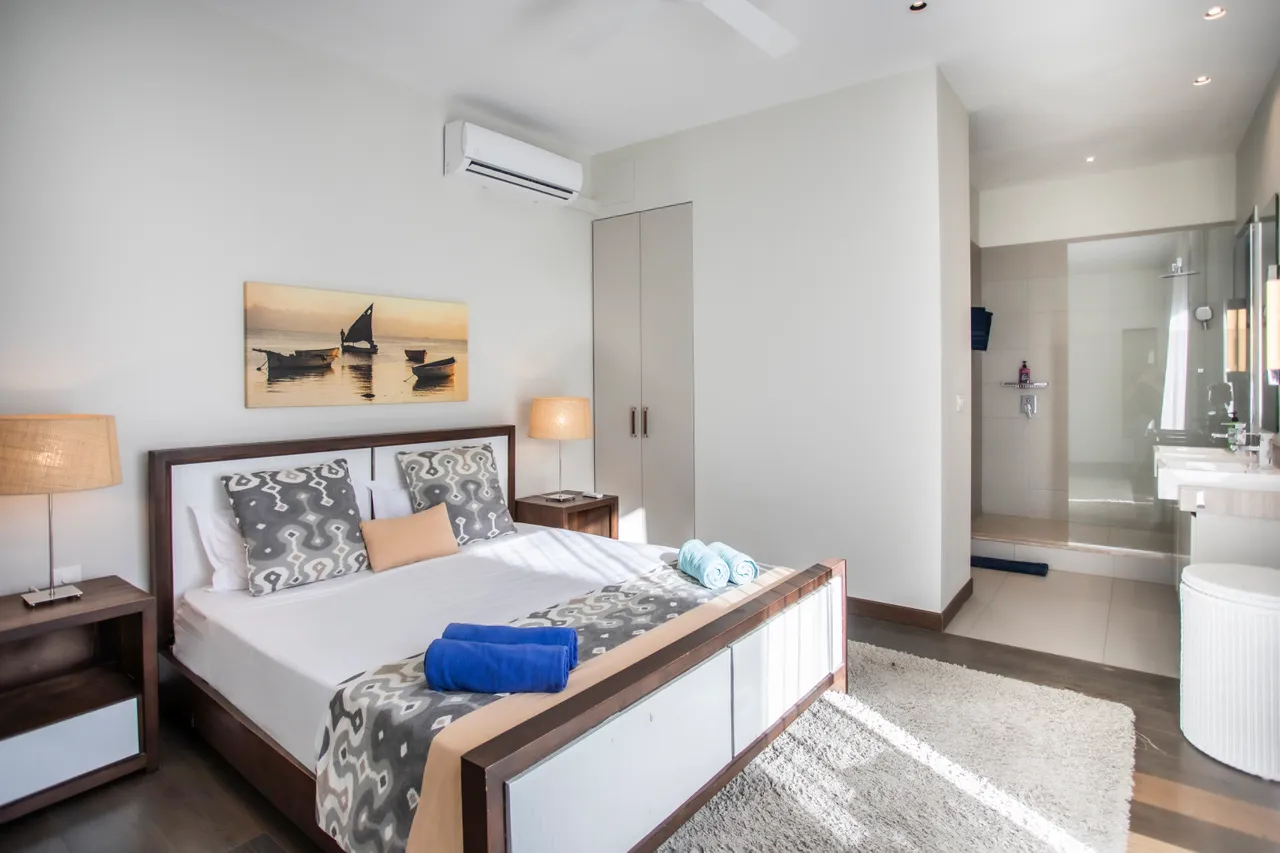 Chambre avec lit double et rangements intégrés. Éclairage doux et décoration minimaliste.