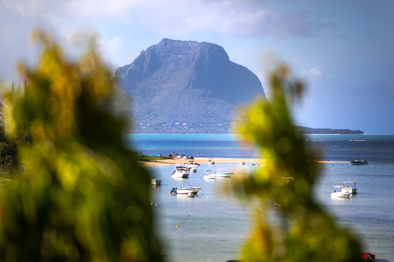 Vue dégagée sur le lagon et la montagne depuis l'espace extérieur. Bateaux au mouillage.