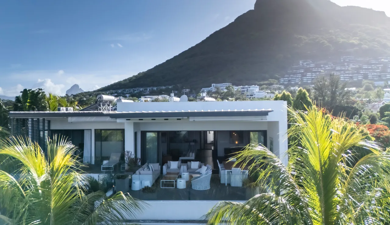 Espace galerie avec mobilier contemporain, grandes baies vitrées et vue sur la montagne.