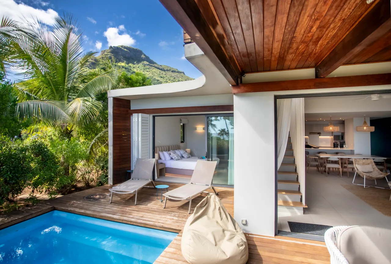 Espace extérieur avec piscine privée et chaises longues en bois.  

Terrasse en bois jouxtant le jardin luxuriant et la villa.  

Coin salon confortable à proximité de la piscine pour se détendre.  

Végétation environnante offrant de l'intimité et un cadre paisible.  

Vue sur la montagne depuis l'espace extérieur, enrichissant l'environnement.