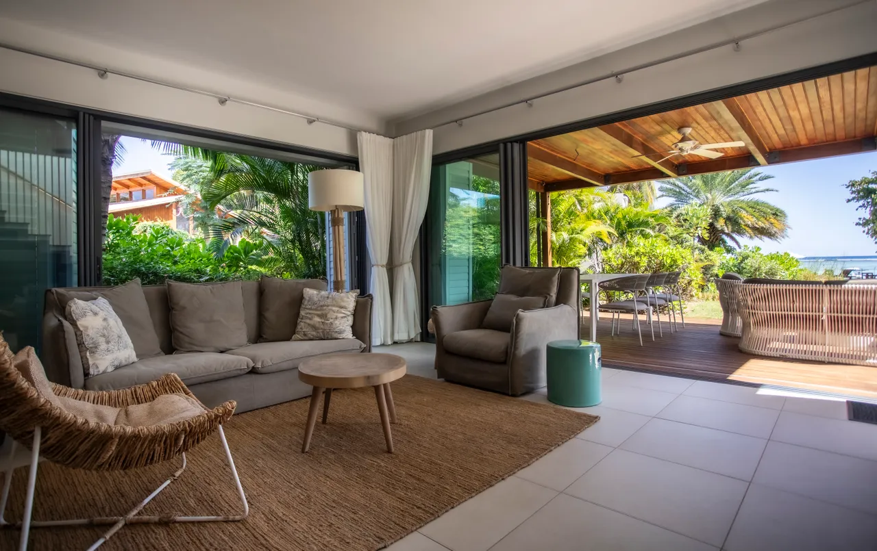 Lumière naturelle abondante grâce aux grandes baies vitrées du salon.  

Mobilier moderne disposé pour favoriser les échanges et la convivialité.  

Accès direct à la terrasse depuis le salon, offrant une vue sur le jardin.  

Espace de vie ouvert avec un décor simple et épuré.  

Ambiance sereine avec une décoration minimaliste et des touches naturelles.