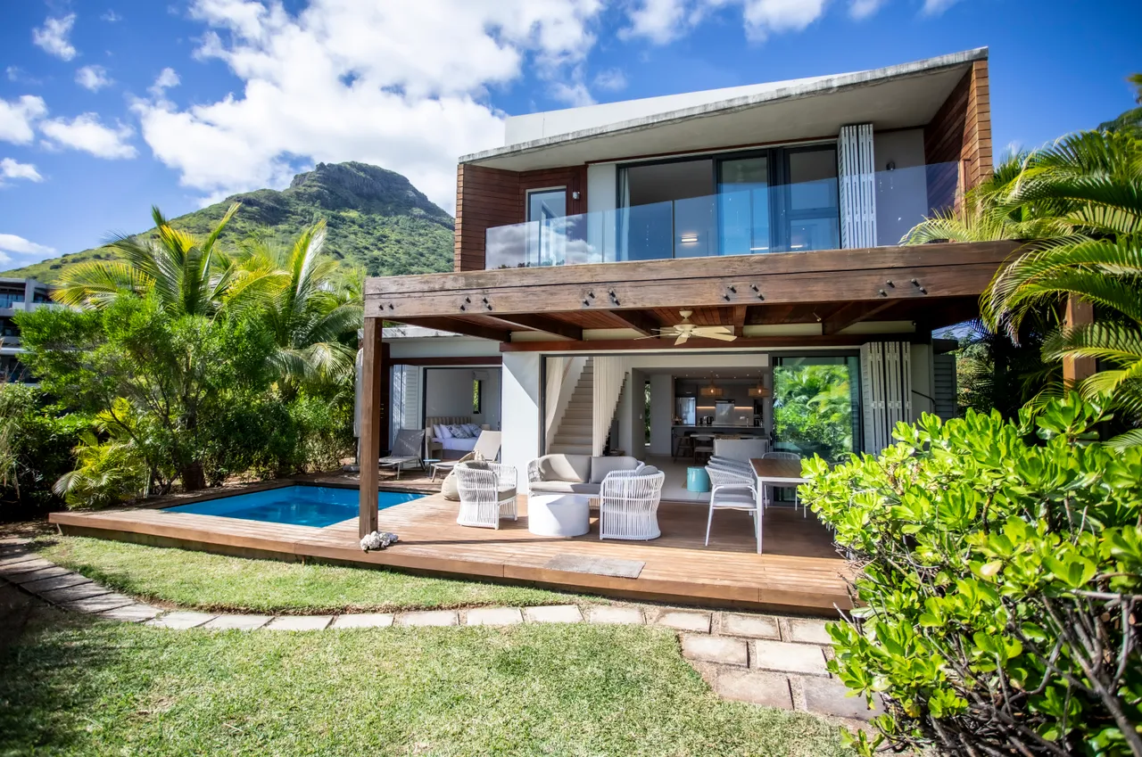 Espace extérieur avec piscine privée entourée de verdure.  

Terrasse en bois offrant un coin salon confortable.  

Végétation tropicale créant une ambiance naturelle et apaisante.  

Accès direct au jardin depuis les espaces de vie.  

Zone ombragée idéale pour se détendre au bord de la piscine.