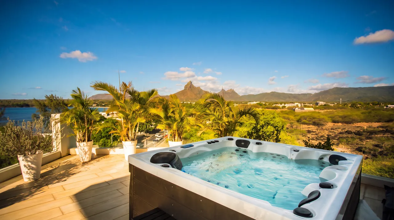 Jacuzzi privé sur la terrasse avec vue panoramique sur les montagnes. Espace extérieur spacieux et ensoleillé.