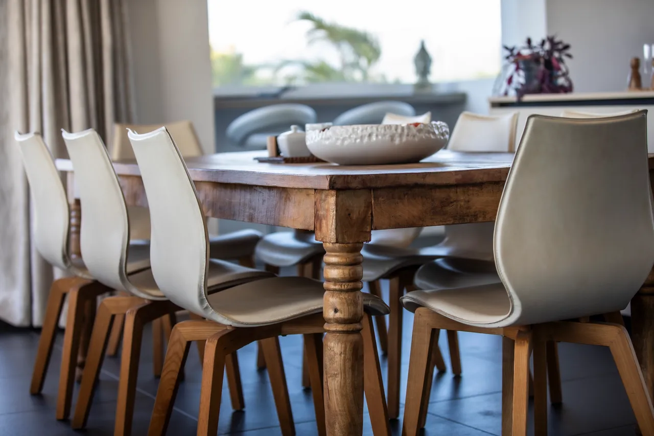 Table en bois massif entourée de chaises rembourrées, idéale pour les repas conviviaux.