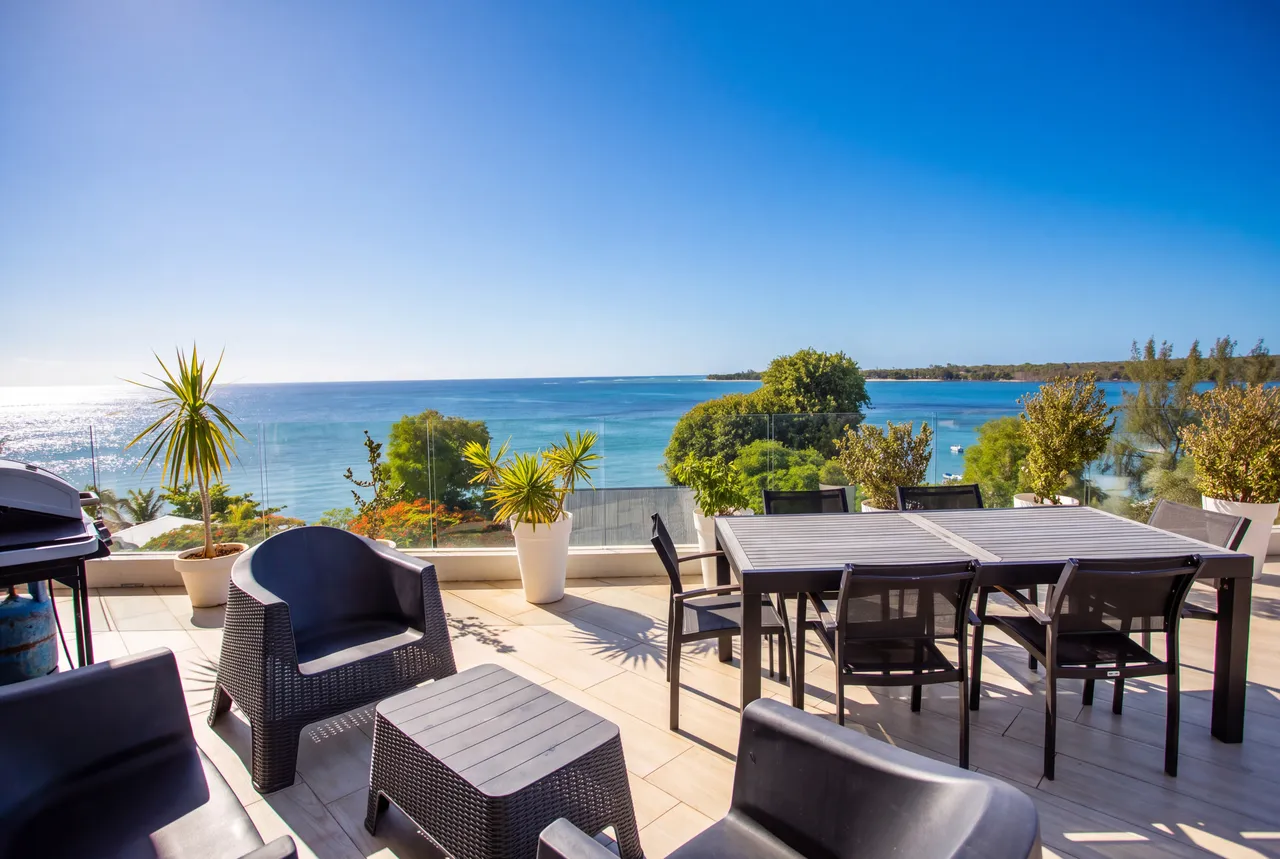 Terrasse avec mobilier extérieur et vue sur la mer. Espace propice à la détente en plein air.