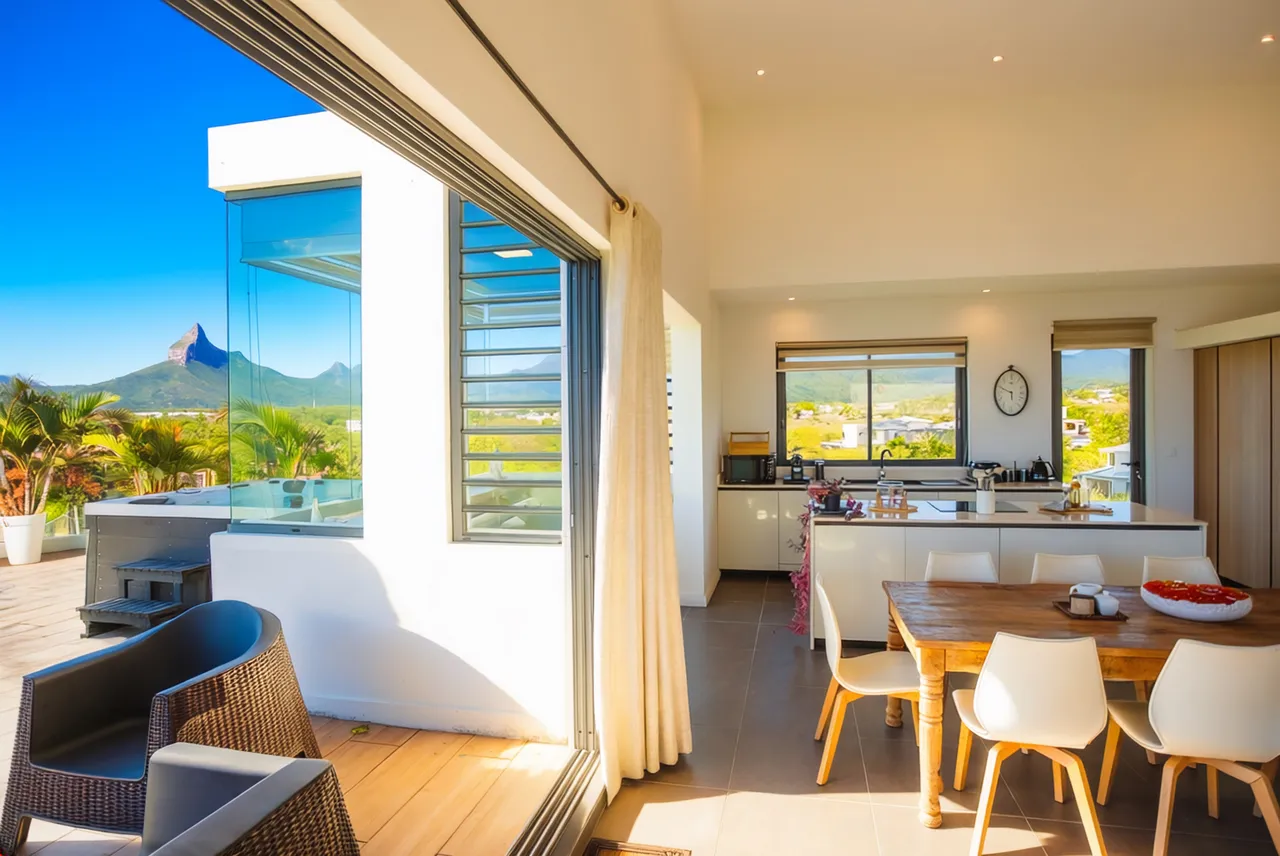Espace de vie ouvert avec cuisine moderne et vue sur la montagne. Mobilier fonctionnel et lumineux.