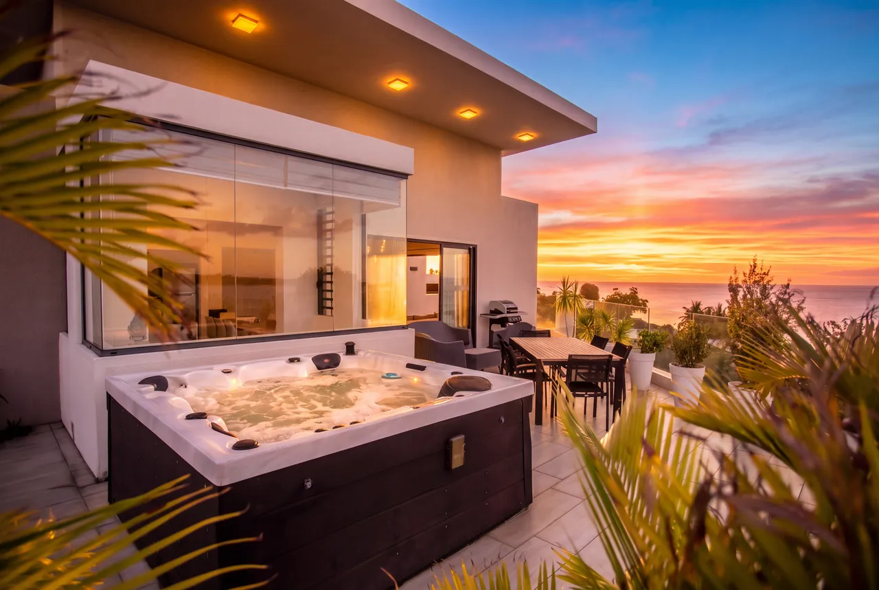 Jacuzzi privé à l'extérieur, offrant des vues panoramiques sur le coucher de soleil.
