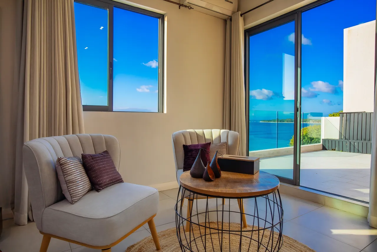 Espace détente avec fauteuils confortables et table basse. Vue dégagée sur la mer.