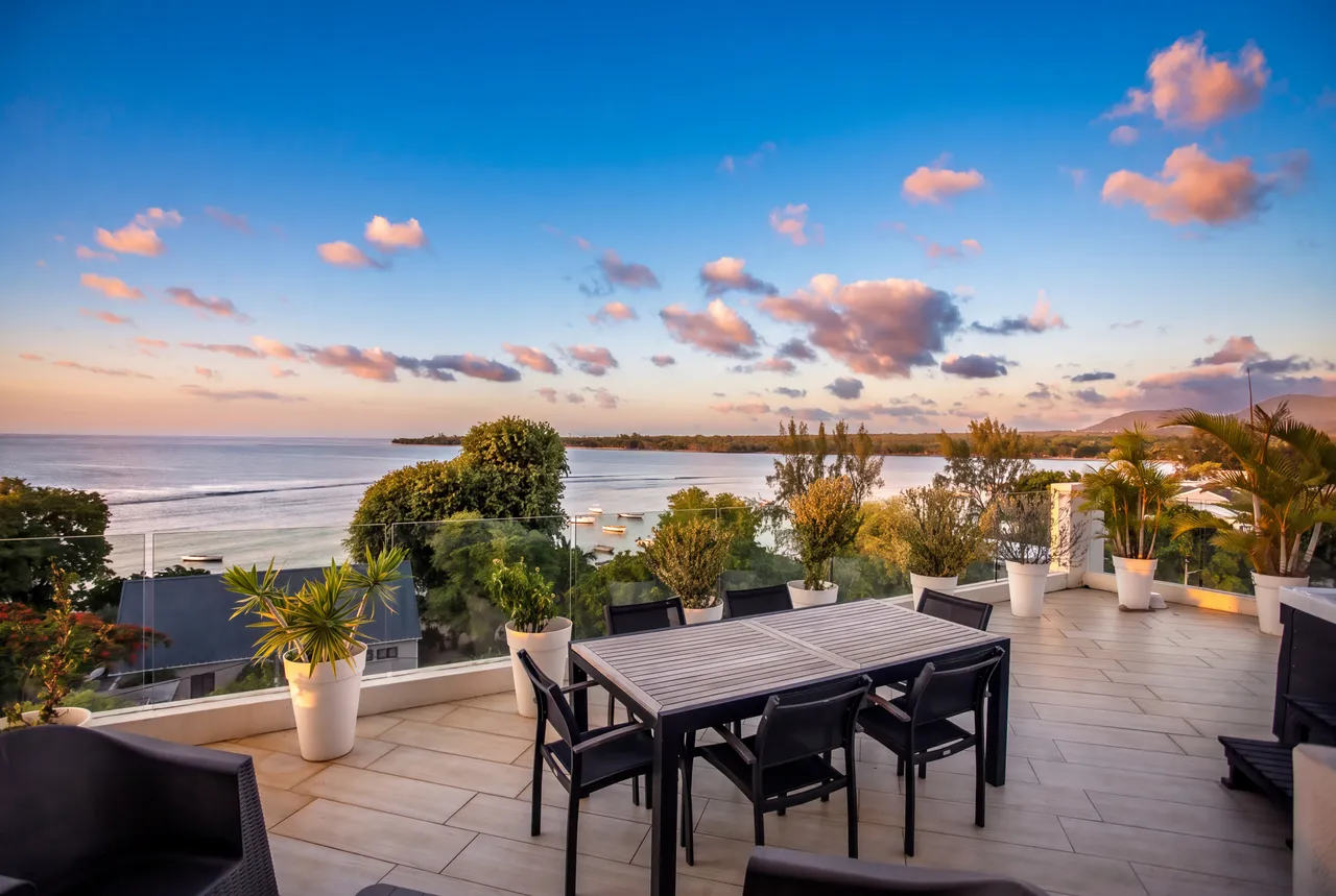 Terrasse en carrelage avec mobilier de jardin et vue sur la mer. Ambiance ouverte et aérienne.