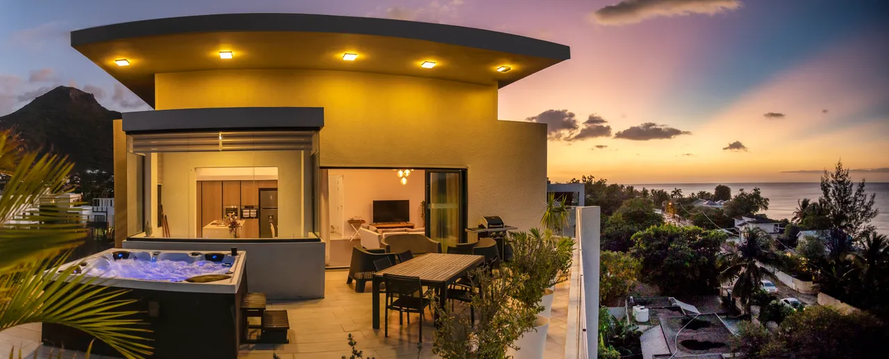 Teintes douces et surfaces modernes sur la terrasse. Espace extérieur avec vue sur la mer.