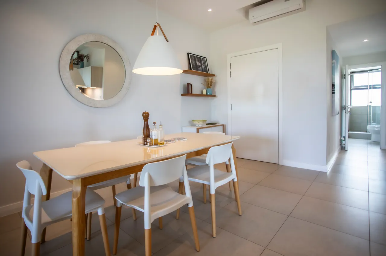 Espace repas avec table en bois et chaises modernes.