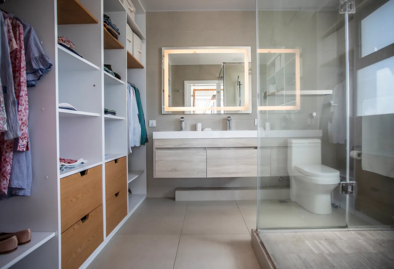Salle de bain avec un meuble double vasque et miroir éclairé.
