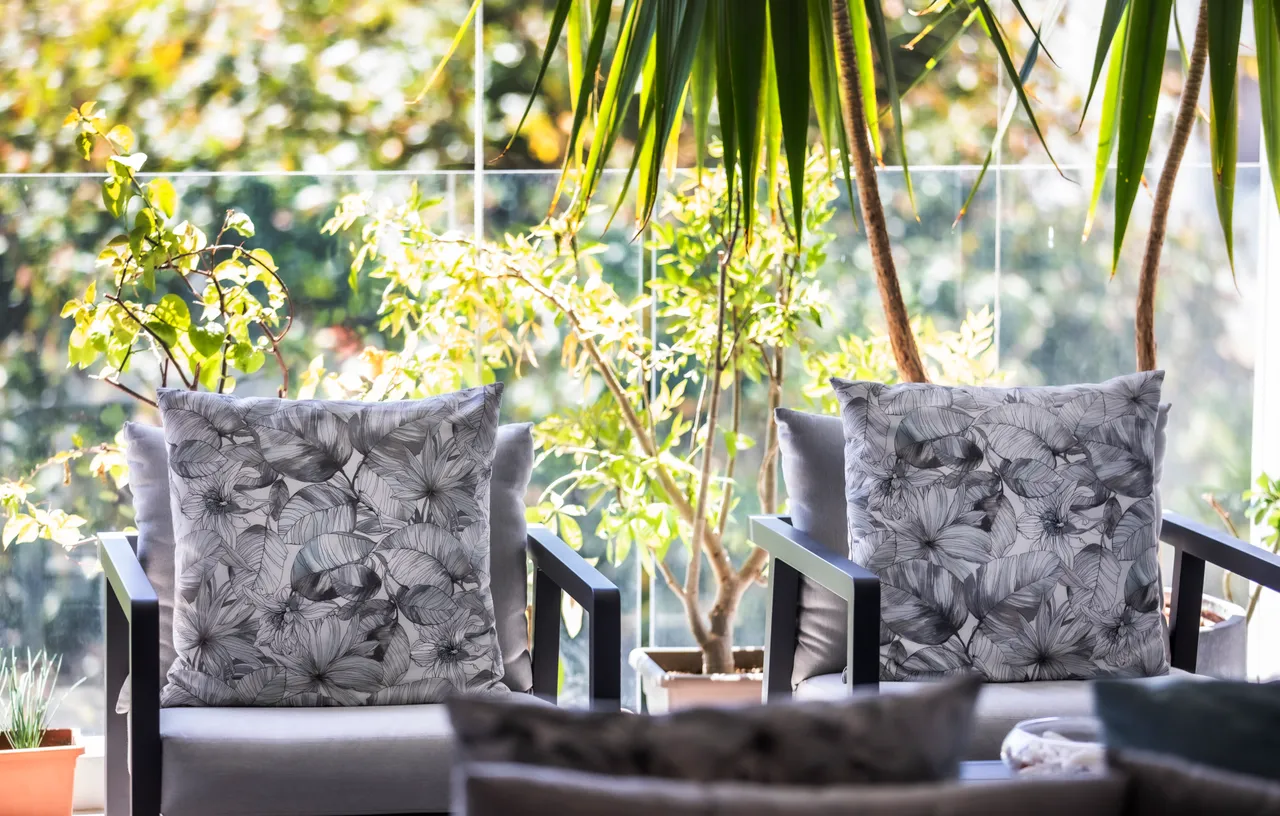 Tons verts et mobilier en bois créent une atmosphère relaxante. Chaises confortables sur le balcon avec vue sur la nature environnante.