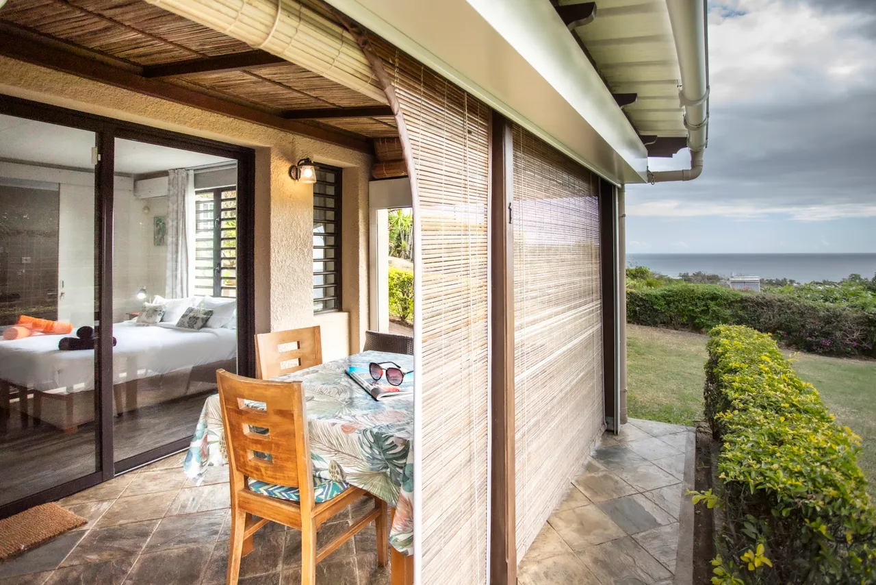 Galerie avec table de jardin et vue sur l'océan.