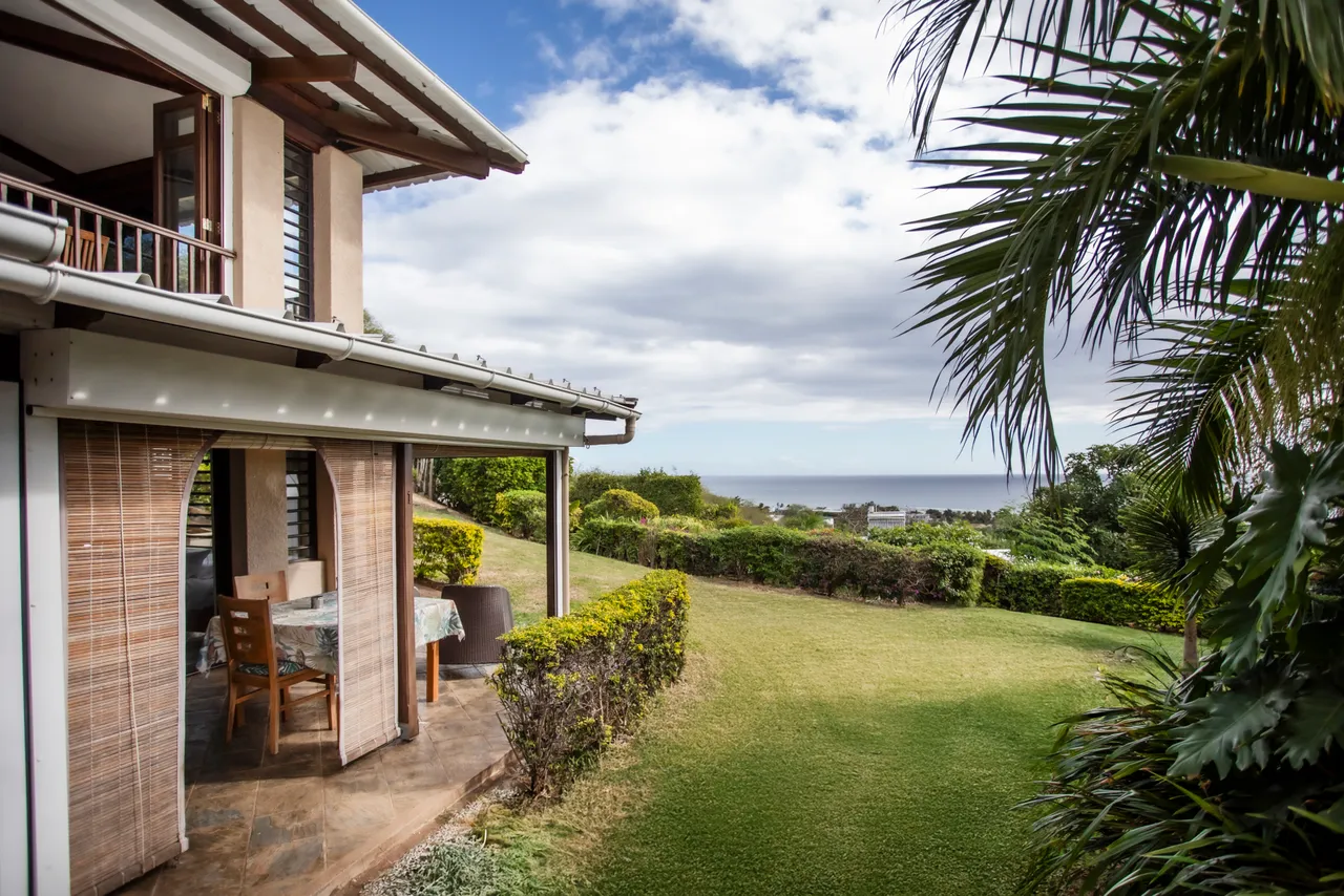 Terrasse extérieure avec mobilier et vue dégagée sur l'océan.